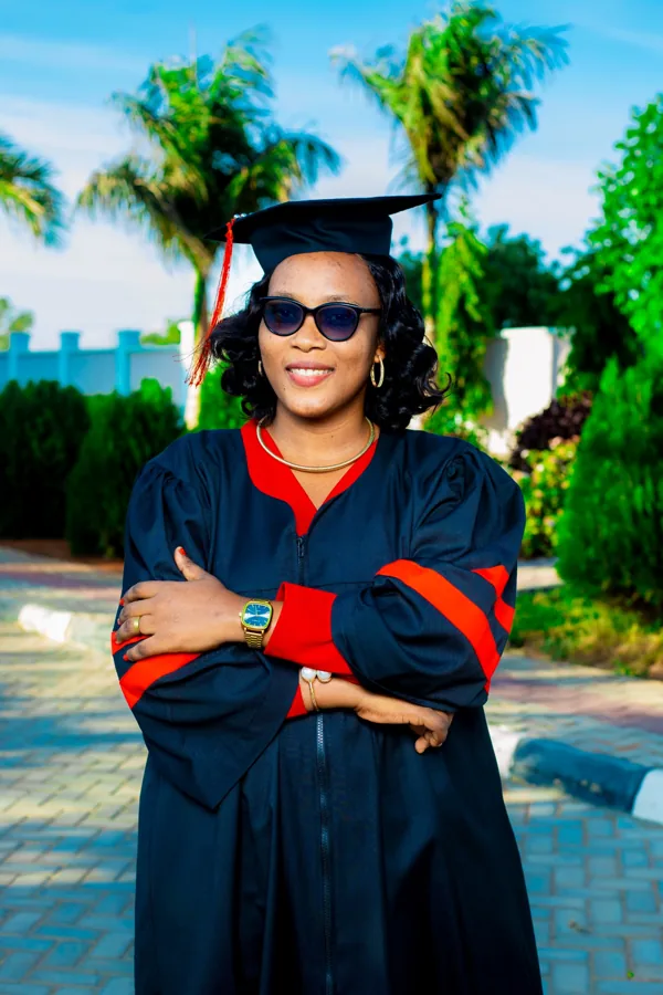 A person in academic regalia pictured on the ACTS grounds.