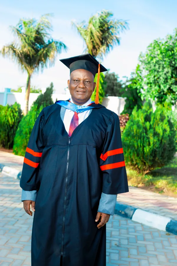 A person in academic regalia pictured on the ACTS grounds.