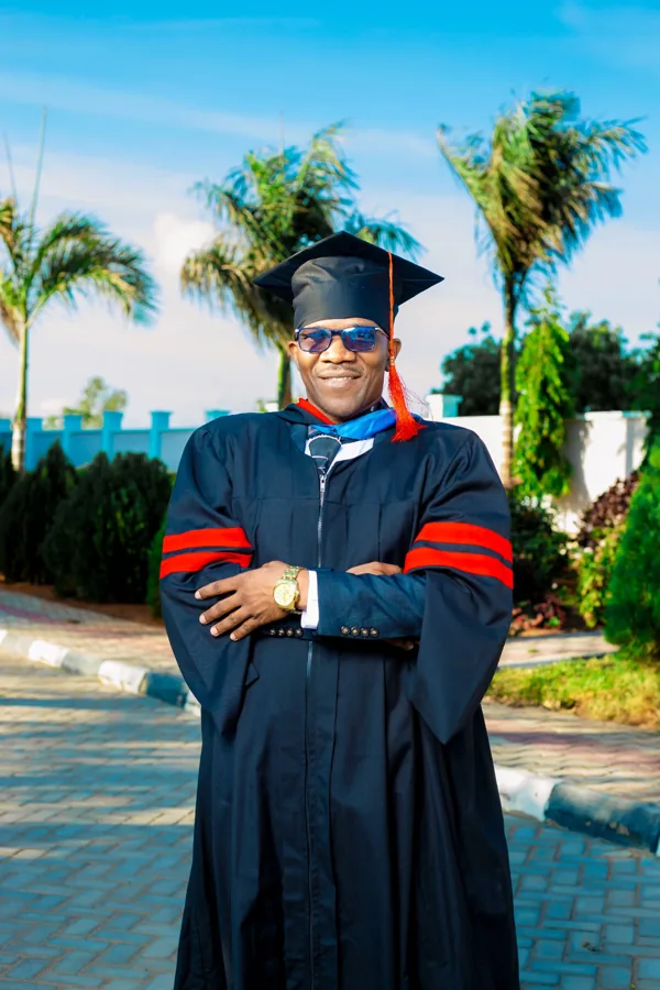 A person in academic regalia pictured on the ACTS grounds.