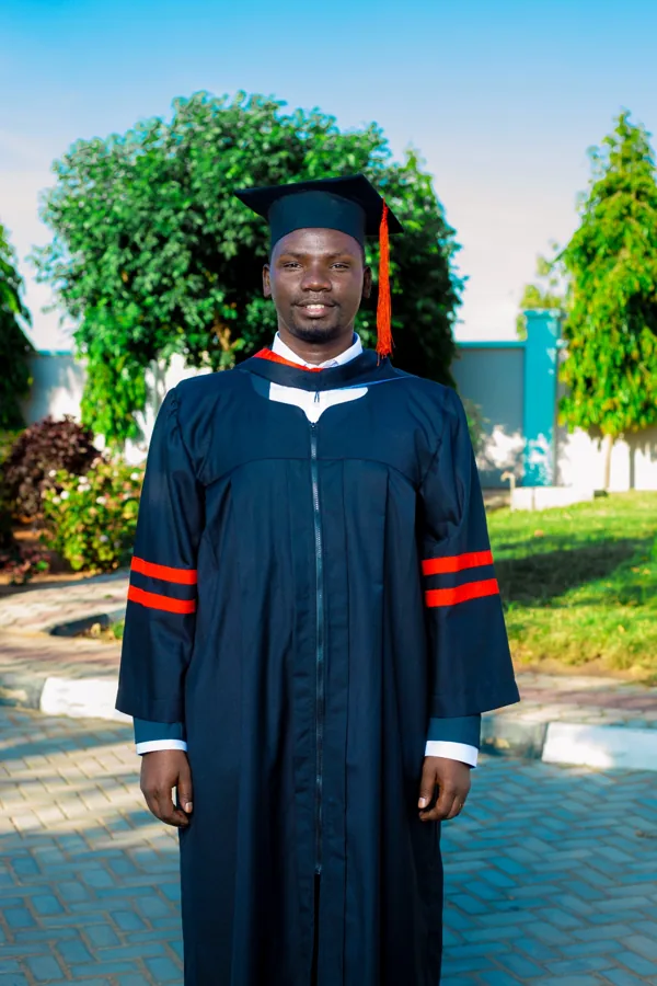 A person in academic regalia pictured on the ACTS grounds.