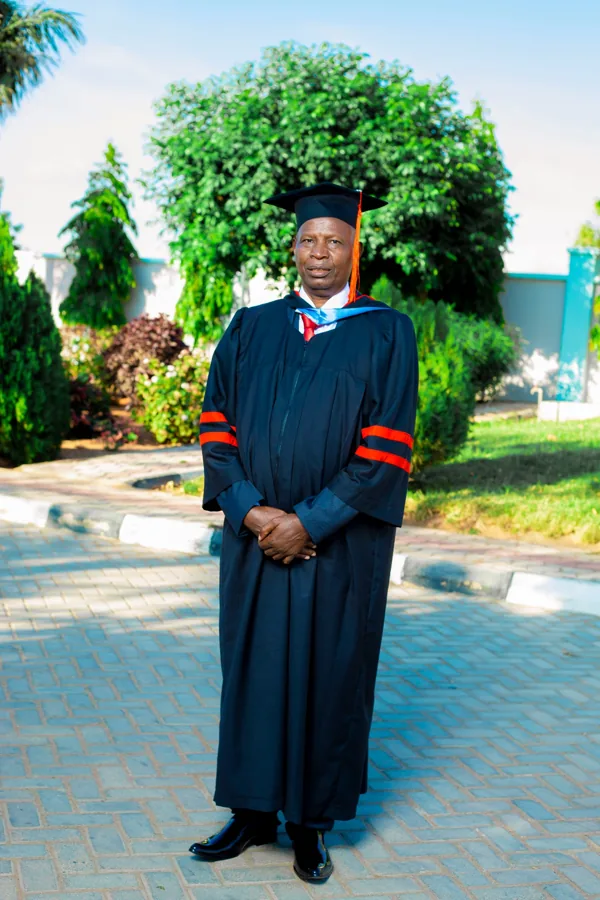 A person in academic regalia pictured on the ACTS grounds.