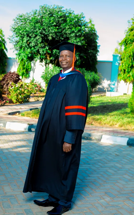 A person in academic regalia pictured on the ACTS grounds.