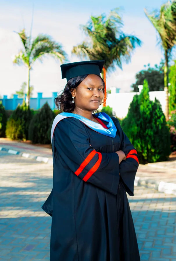 A person in academic regalia pictured on the ACTS grounds.